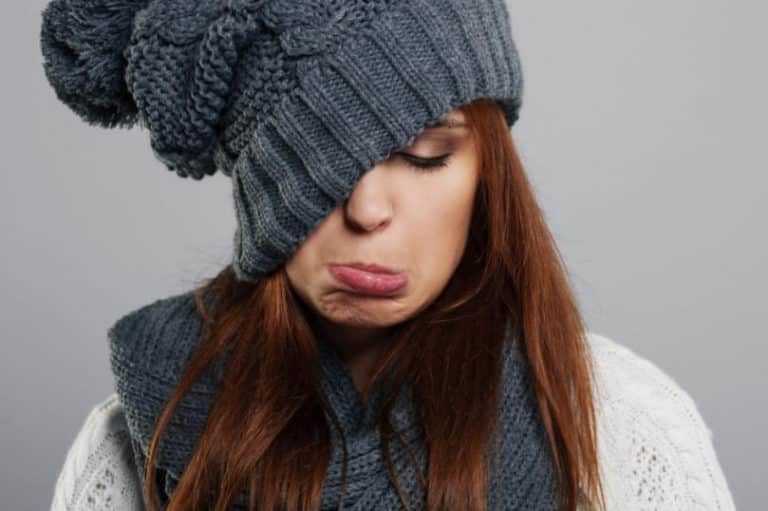 jeune femme habillé chaudement pour l'hiver et un peu triste